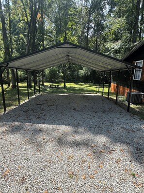 Un espace extérieur abrité, doté d’un sol en gravier et entouré d’arbres.