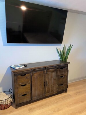 Eine Holzkabine mit Schubladen und einem an der Wand darüber befestigten Fernseher.
