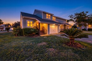 A two-story house with a front porch, a garage, and a well-maintained lawn. - Mariner Lakes 14 Serenity & Sandy Shores (Orange Beach)