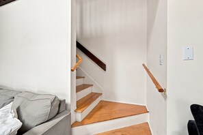 Eine Treppe mit Holzhäuschen und Handlauf, die zu einer Zwischenebene führt.
