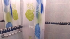 Een badkamer met toilet, wastafel en douchegordijn.