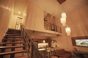 A spacious living area with a staircase, a kitchen, and a dining area. - Villa Nómada | Private Pool and the Perfect Getaway in Atlixco (Atlixco)