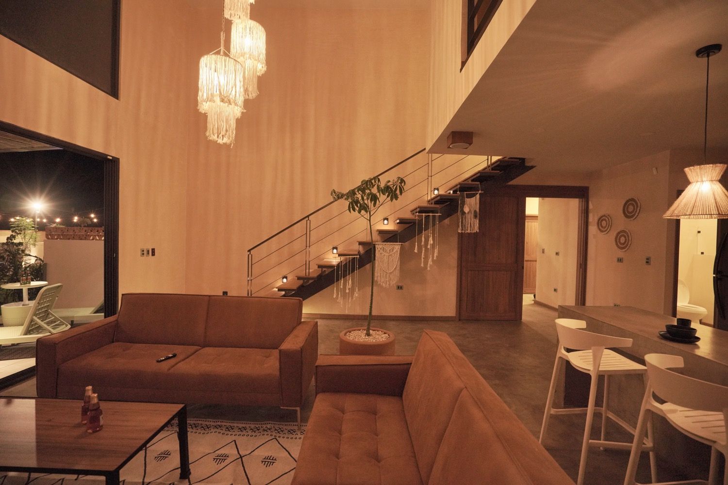 A modern interior with a staircase, seating area, and dining space.
