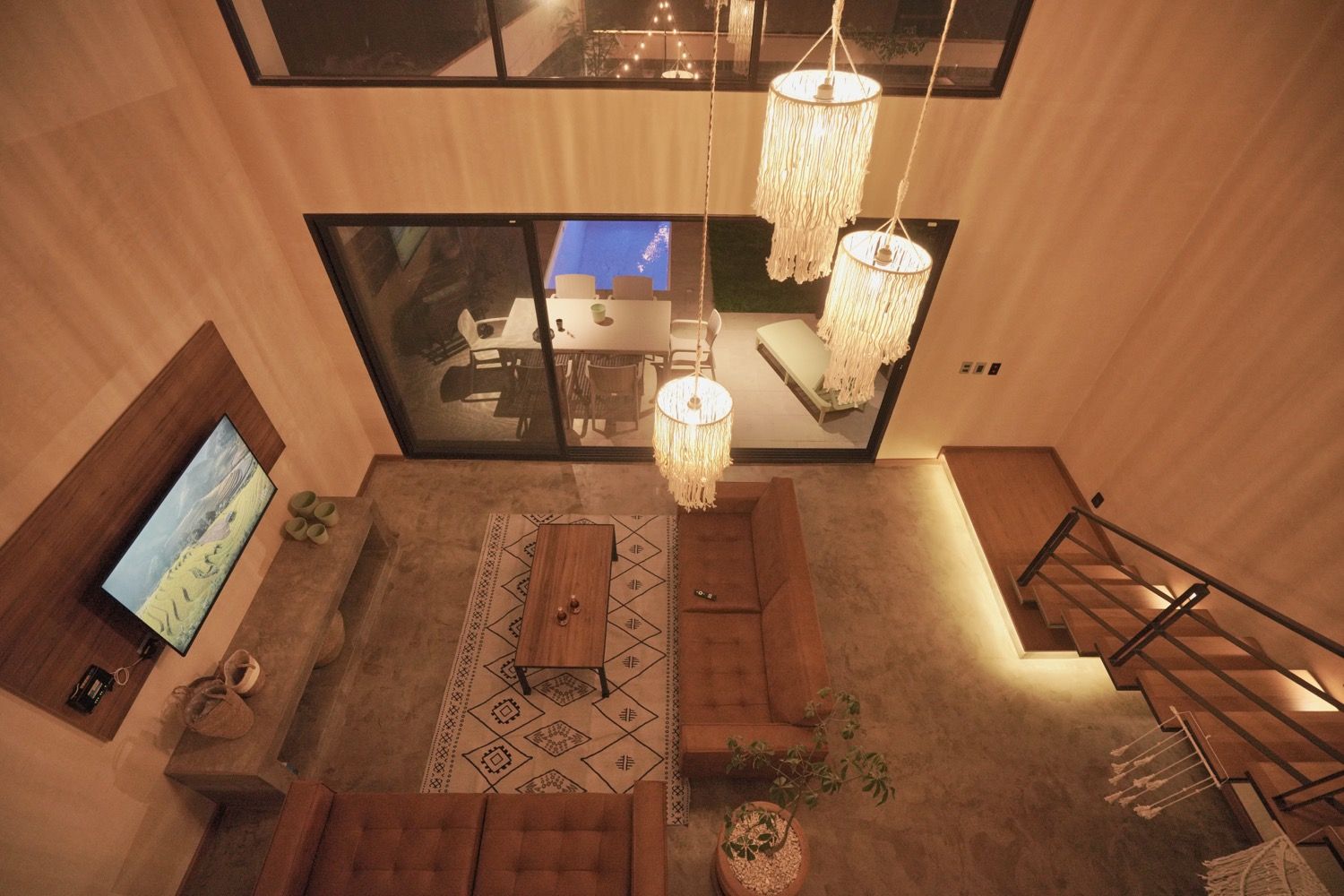 A modern interior with a sofa, coffee table, and hanging lights.