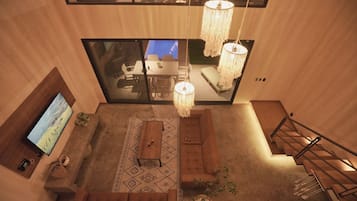 A modern interior with a sofa, coffee table, and hanging lights.