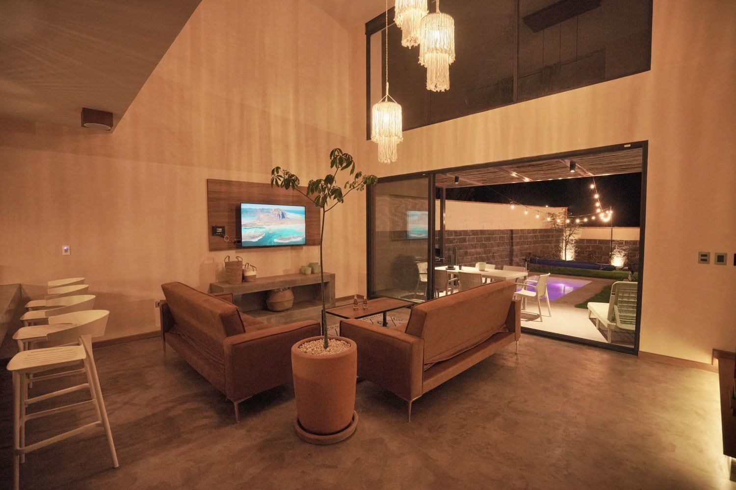 A modern interior with a seating area, a television, and a view into an adjacent space.