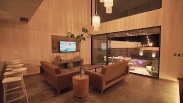 A modern interior with a seating area, a television, and a view into an adjacent space.
