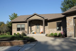 A two-story house with a stone facade, a front porch, and a clear sky. - *Nature* clean* spacious* five bedroom* 3 bathroom . (Wellman)
