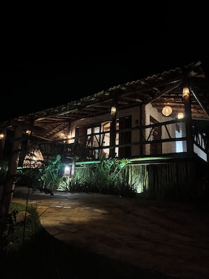 A traditional building with a wooden structure, large windows, and a covered porch area. - Vila calm - bangalos  (Várzea do Giló)