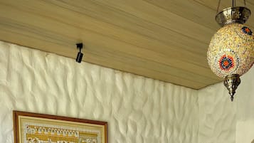 Ein Bett mit einer gesteppten Decke, eine Wandlampe und ein gerahmtes Bild.