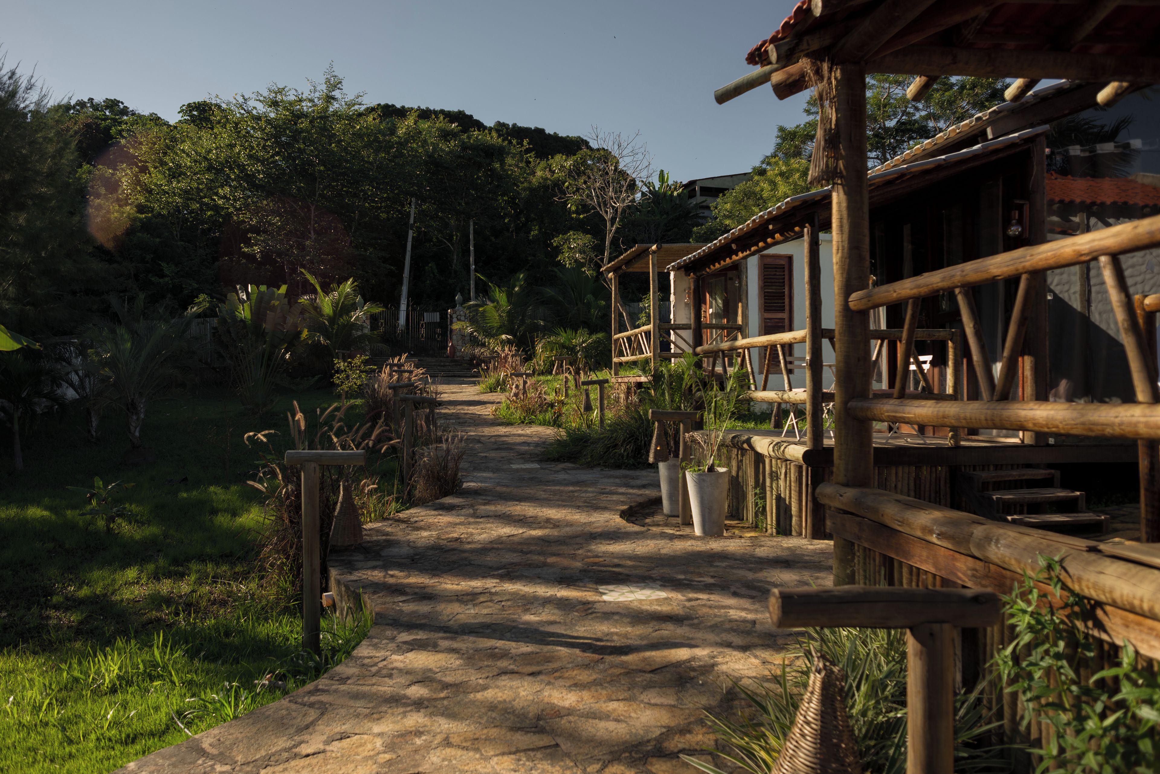 A rustic wooden pathway leading to a traditional building with a thatched roof.