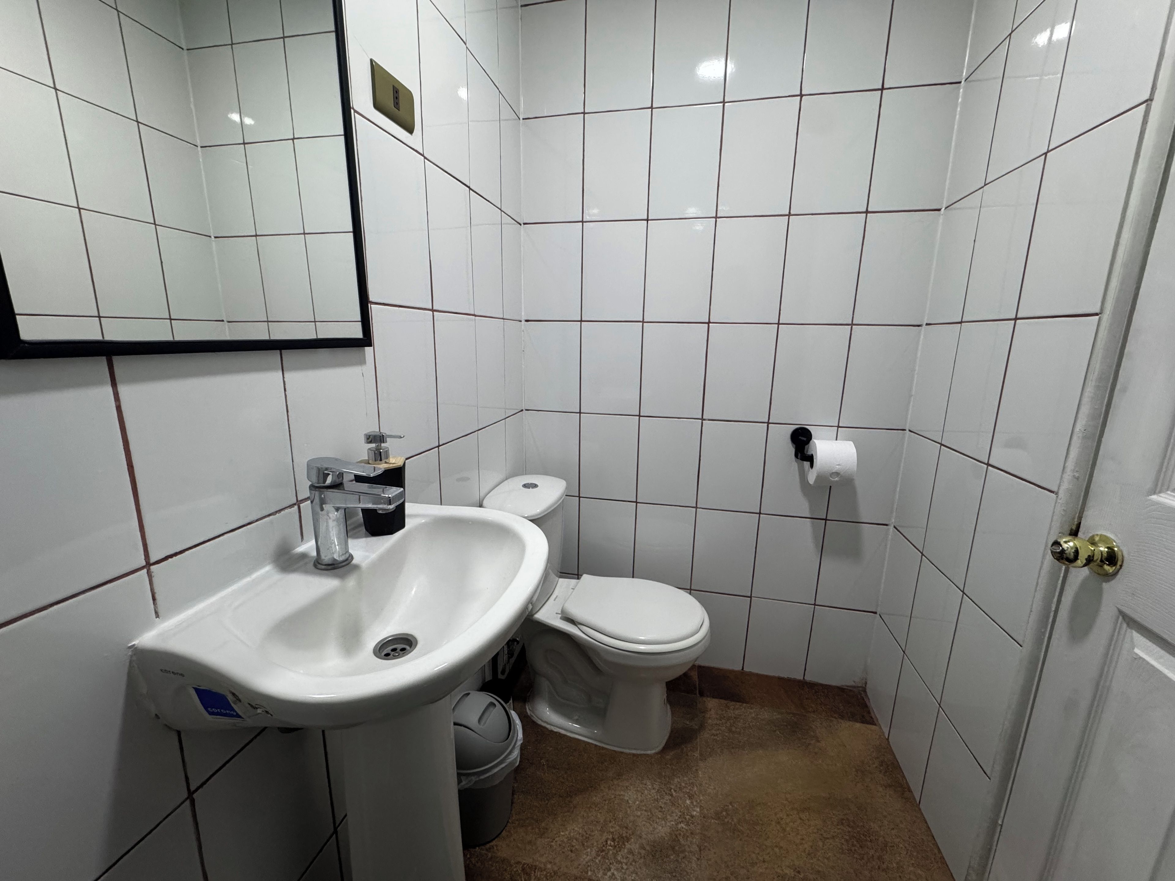 Un baño pequeño con lavamanos, inodoro y espejo.