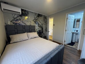 A bedroom with a bed, a headboard, and a wall with a marble-like design. - Tranquil studio with AC in beautiful Talca city center (Talca)
