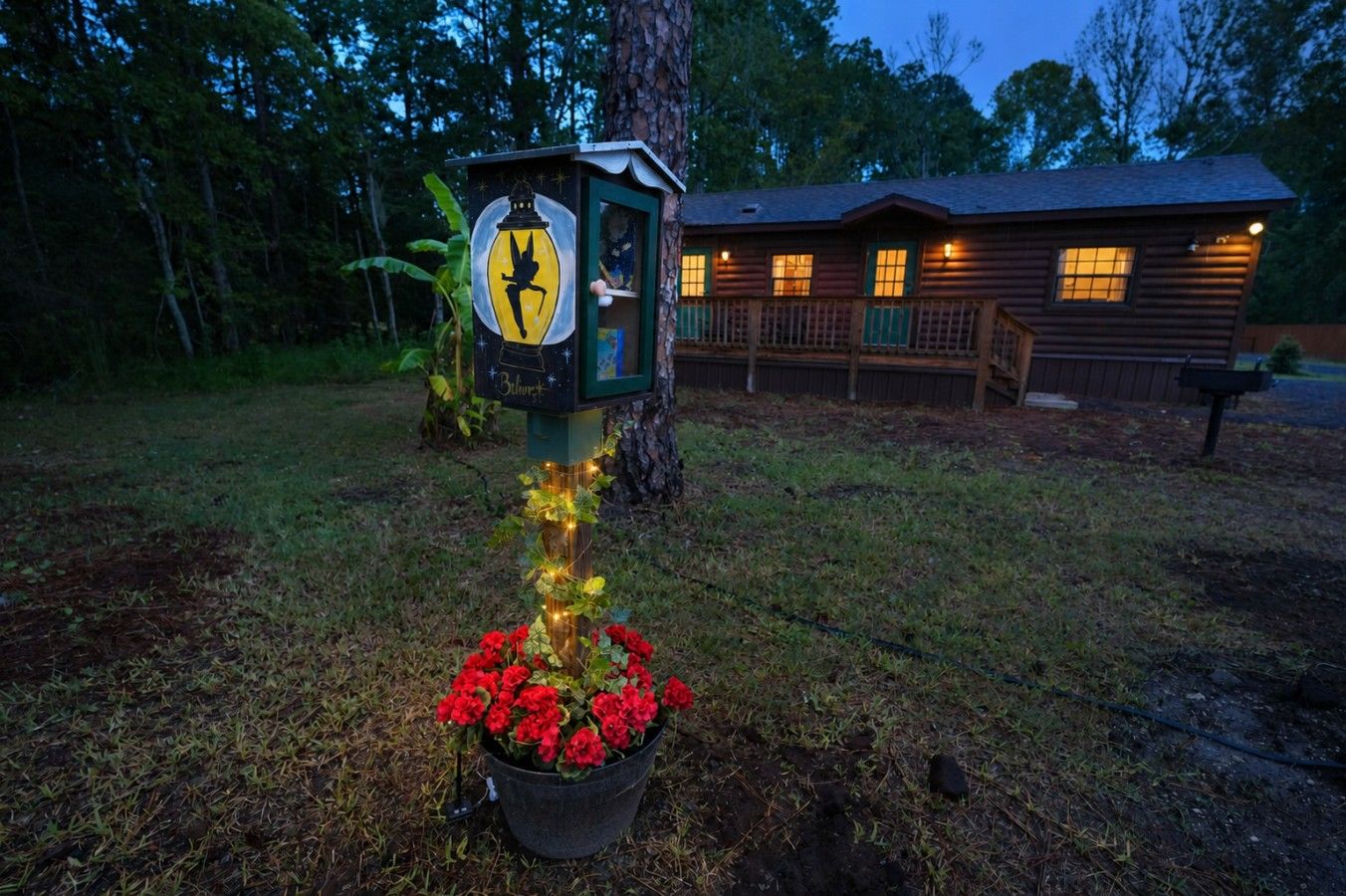 A cabin with a porch and a mailbox with a birdhouse.