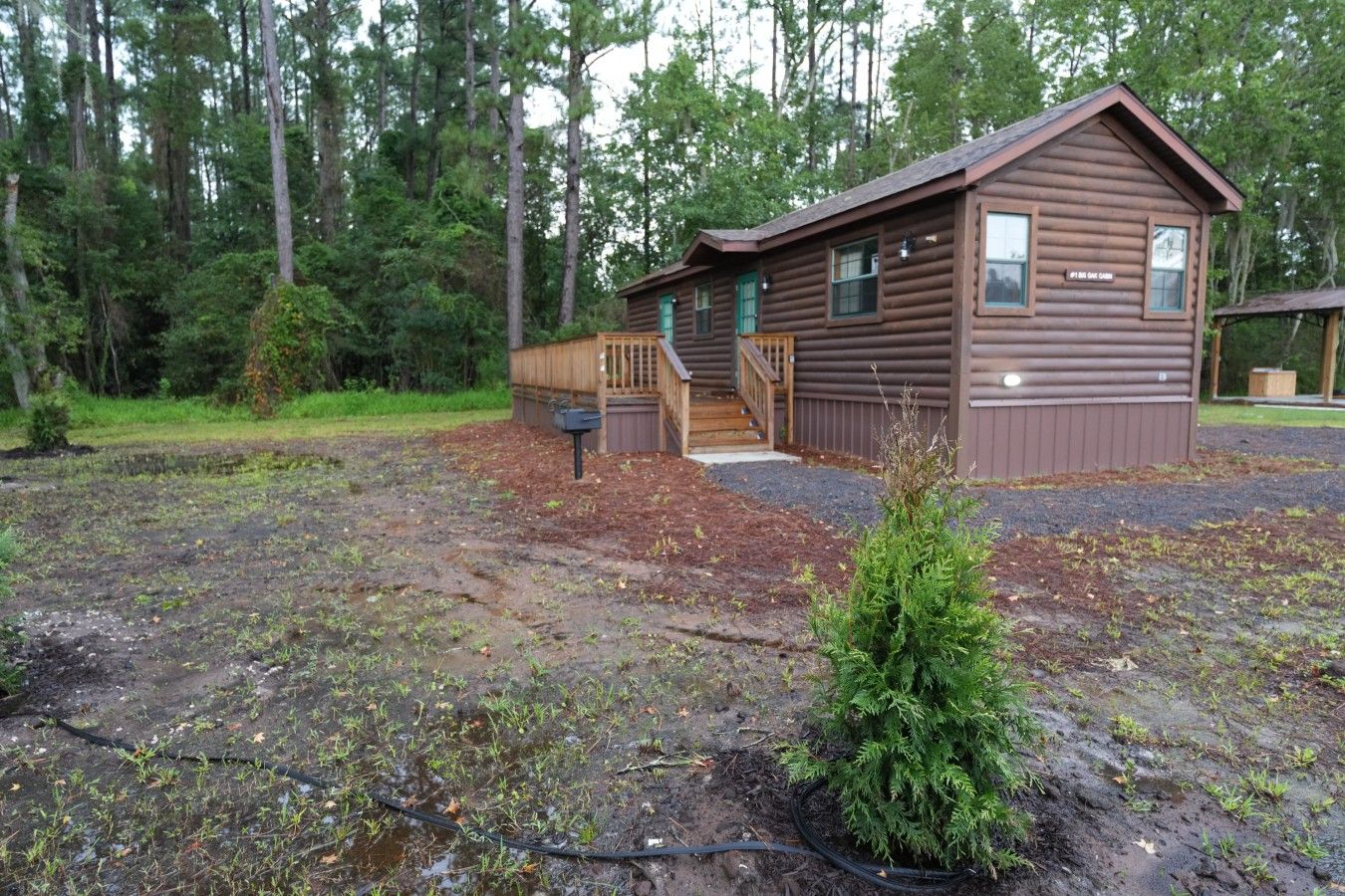 A cabin with a wooden deck, a small porch, and a mailbox.