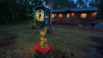 Eine Holzhütte mit Veranda und Briefkasten sowie Vogelhaus.