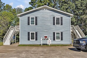 A two-story building with a gabled roof, a front porch, and a staircase on the left. - Vintage Farmhouse Charm - 8 Min to Duke and DT (Durham)