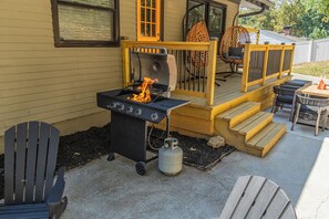 Una terrazza esterna con un barbecue, mobili da giardino e un pontile.