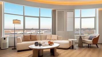 Une chambre d’hôtel moderne dotée d’une grande fenêtre donnant sur un aéroport.
