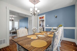 A dining room with a wooden table, chairs, and a chandelier. - Charming 3-bedroom house near KC that sleeps up to 8 with gazebo and coffee bar. (Olathe)