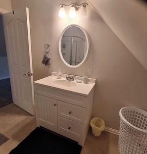 A bathroom with a white vanity, a round mirror, and a towel ring. - Country Quiet, Town Close - Charming Cleveland Cottage Near OCI & More (Cleveland)