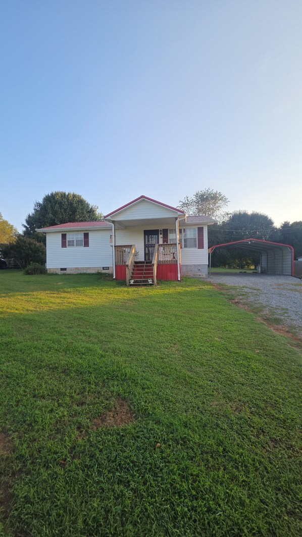 A single-story house with a porch, a garage, and a well-maintained lawn.