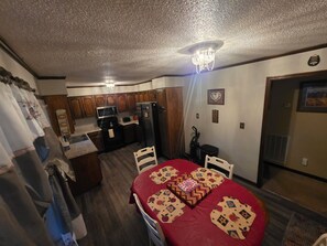 A compact kitchen with wooden cabinets, a microwave, and a refrigerator.