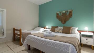 Un dormitorio con una cama, mesitas de noche y un cuadro colgado en la pared.