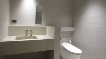 Ein modernes Badezimmer mit Waschbecken, Spiegel und Toilette.