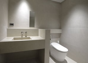 Ein modernes Badezimmer mit Waschbecken, Spiegel und Toilette.
