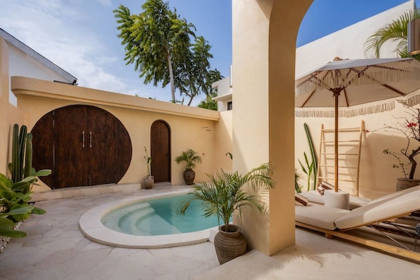 A pool area with a circular pool, a wooden door, and a lounge chair under a canopy. - NEW 3BR Boutique Villa w/ Private Pool - Bingin (South Kuta)
