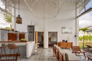 A modern interior with a kitchen, dining area, and a bedroom with a canopy bed. - 3BR Garden Villa w/ Expansive Pool in Bingin (South Kuta)