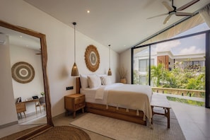 A modern bedroom with a large bed, bedside tables, a mirror, and a view of the outdoors. - Belluci Uluwatu | 1BR Modern Villa w/ Pvt Pool (South Kuta)