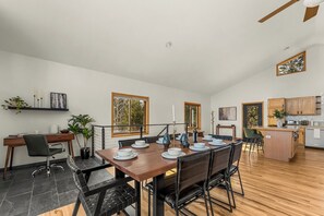 A spacious dining area with a wooden table set for four, surrounded by black chairs. - Modern Private 3 Acres w/ Hot Tub and Game Room (Bailey)