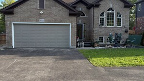 Una casa a due piani con garage, un giardino anteriore e un vialetto.