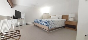 A bedroom with a bed, bedside table, lamp, and a desk with a chair. - Steps from Wells Beach, Bellevue by the Sea is perfect for your Maine vacation (Wells)
