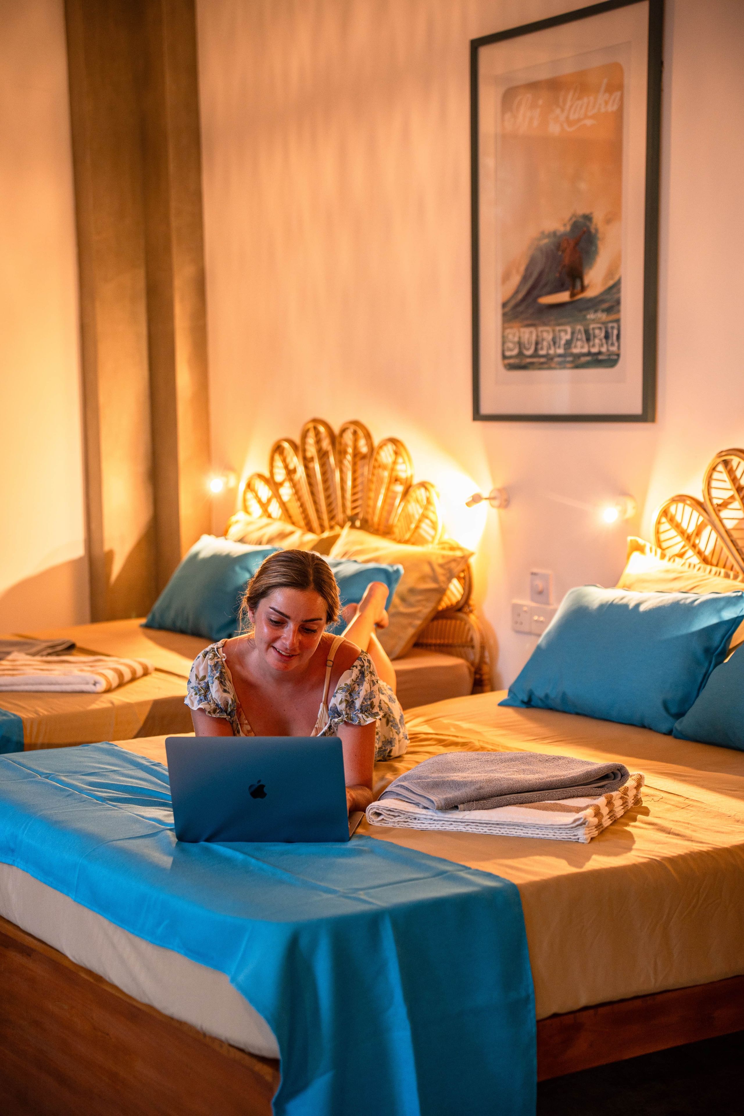 Ein Hotelzimmer mit einem Bett, einem Laptop und einem gerahmten Bild an der Wand.
