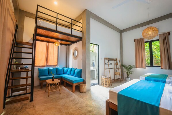 Quarto com beliche, sofá, mesa pequena, luminária pendente e janela com cortinas.