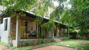 Ein modernes Haus mit einer überdachten Veranda, einem Kiesweg und einem Garten.