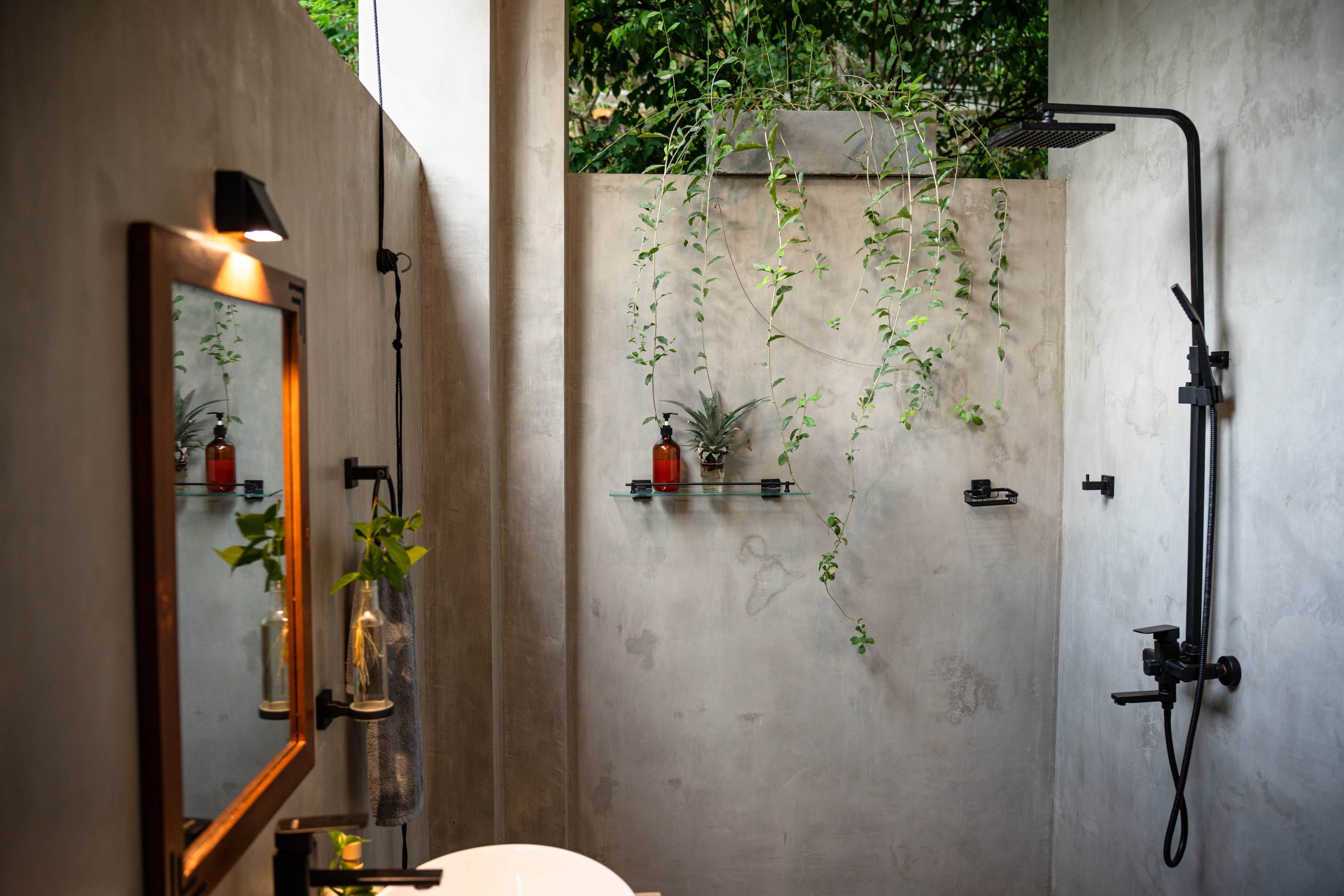 A modern bathroom with a large mirror, a shower, and shelves with toiletries.