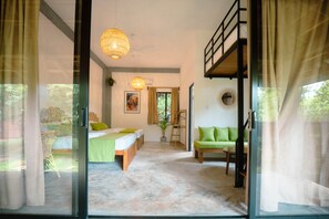 Quarto com cama, um banco, luminária pendente e janela.
