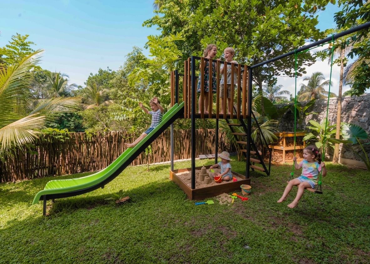 Un'area giochi con scivolo, struttura per arrampicata e altalene.