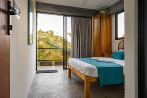 Une chambre avec un lit, une vue sur l’extérieur et un balcon.