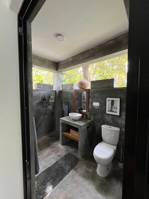 Une salle de bain compacte comprenant un lavabo intégré, des toilettes et un espace douche.