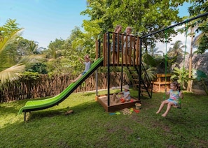 A playground with a slide, climbing structure, and swings.