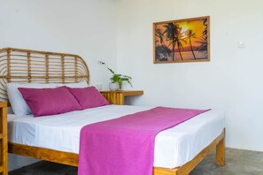A bed with a wooden frame, white bedding, and a pink blanket.
