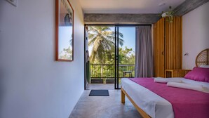 A bedroom with a bed, a view of palm trees, and a balcony. - The Orchid Room (Maaliyadda)