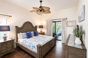 A bedroom with a bed, nightstands, a ceiling fan, a window with blinds, a view of the outdoors, and a potted plant. - Serene Pool & Lake Retreat Sleeps8 Tarpon Springs (Tarpon Springs)
