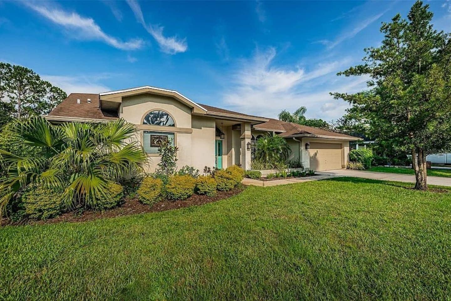 A single-story house with a front porch, a garage, and a well-maintained lawn.