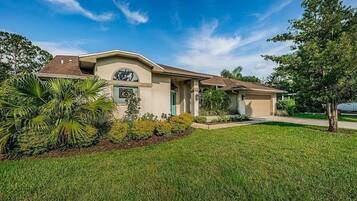 A single-story house with a front porch, a garage, and a well-maintained lawn.